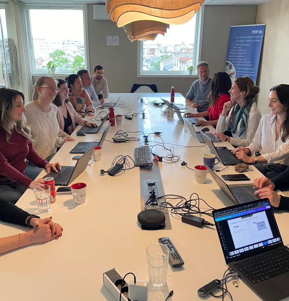 Scène collective d'échange interactif FranceIA Apprenants au travail autour de la grande table d'une session France IA